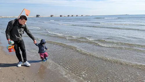 My daughter and I searching for mussels on the beach in Italy fully clothed in October