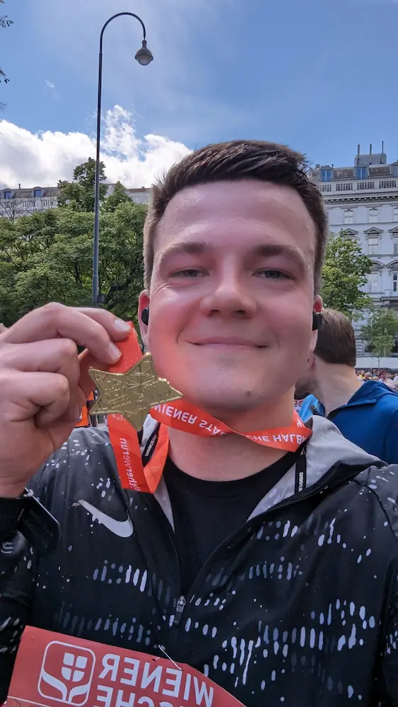 A Selfie. I'm sweaty but smiling, holding my medal into the camera after the marathon.