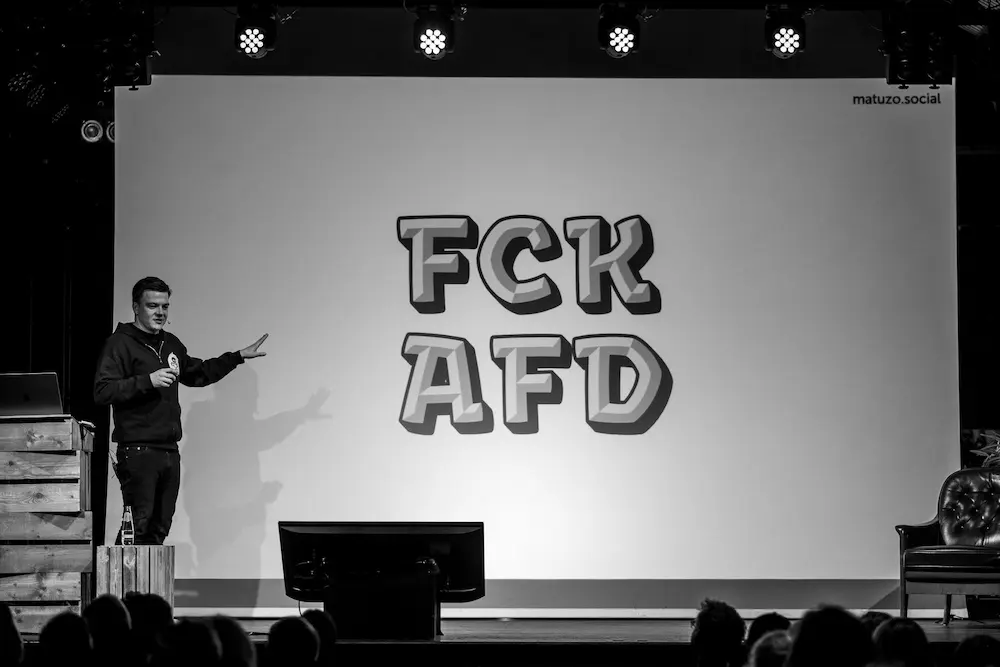 Me presenting on stage showing a color font. The slide shows FCK AFD in large type.